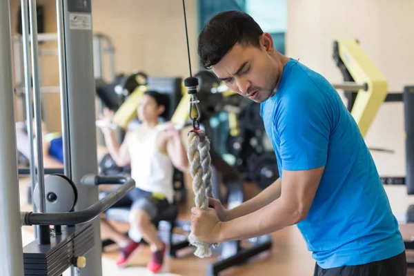 Joven ejercitando tríceps empujar durante el entrenamiento intenso en el gimnasio — Foto de Stock