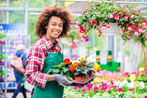 Portrait of a cheerful young woman working as florist in a modern flower shop — Stock Photo, Image