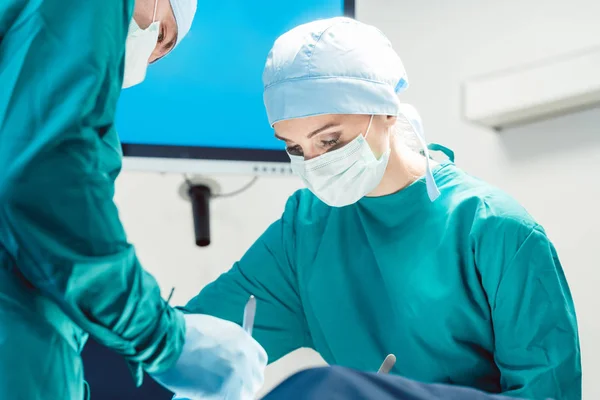 Equipe de cirurgiões na sala de cirurgia durante a cirurgia — Fotografia de Stock