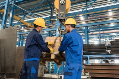 İki işçi ağır yükleme Crane tarafından kaldırdı işleme