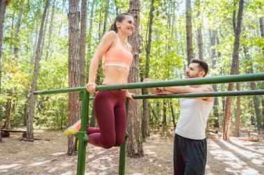 Sağlıklı kadın üzerinde paralel bar erkek arkadaşıyla egzersiz