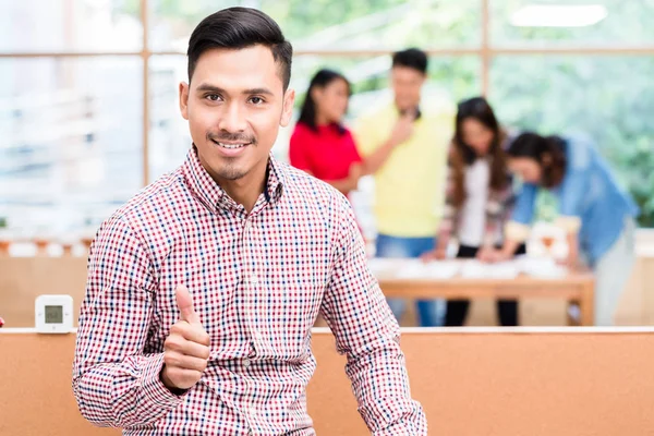 Retrato de joven confiado empleado asiático mostrando pulgar hacia arriba —  Fotos de Stock