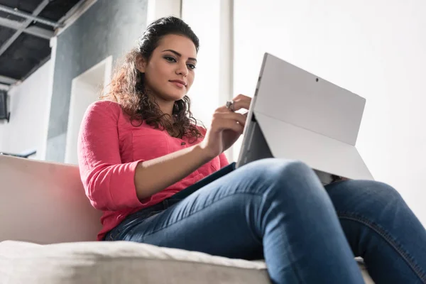 Ung frilansare sitter i fåtölj i byrån arbetar på bärbar dator — Stockfoto