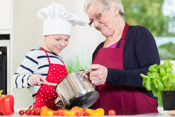 Бабушка готовит вместе с внуком — стоковое фото