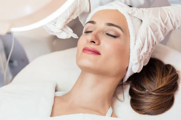 Mulher bonita relaxante durante o tratamento facial não invasivo — Fotografia de Stock