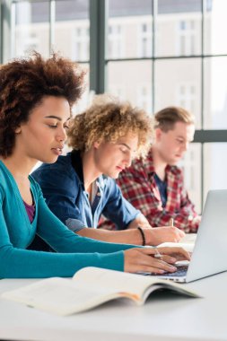 Bir metin okurken bir kitap bir kalem tutan öğrenci yakın çekim