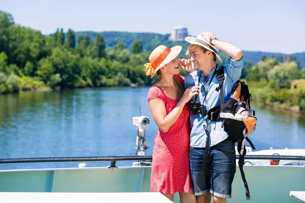 Casal em cruzeiro no rio usando chapéus de sol no verão — Fotografia de Stock