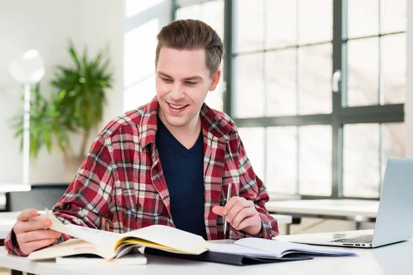 Retrato de un joven estudiante sonriendo mientras investiga información —  Fotos de Stock