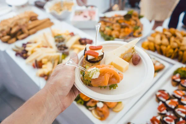 Homem ajudando-se em Buffet de festa ao ar livre levando comida — Fotografia de Stock