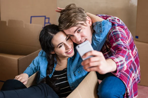 Feliz joven hombre y mujer haciendo una selfie después de mudarse juntos — Foto de Stock