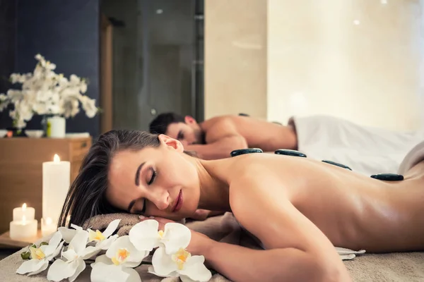 Casal jovem relaxante sob os efeitos estimulantes de uma massagem de pedra quente — Fotografia de Stock