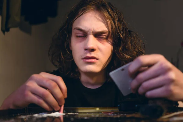 Drogadicto adolescente sosteniendo una factura enrollada mientras resoplaba — Foto de Stock