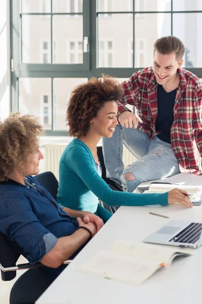 Entspannter junger Student unterhält sich in der Pause mit seinen Mitschülern — Stockfoto