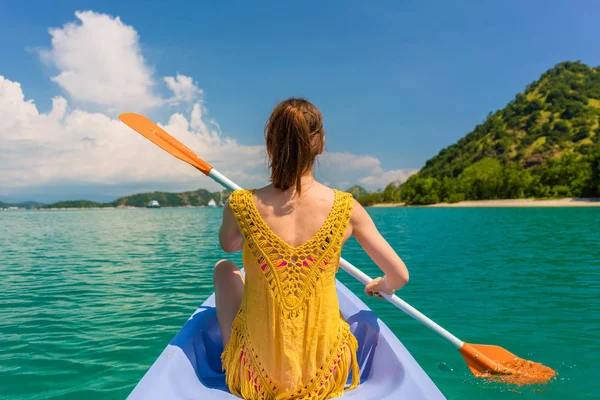 Jovem mulher remando uma canoa durante as férias na Ilha das Flores — Fotografia de Stock