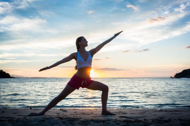 Savaşçı yoga pose günbatımı karşı pratik uygun bir kadın silüeti