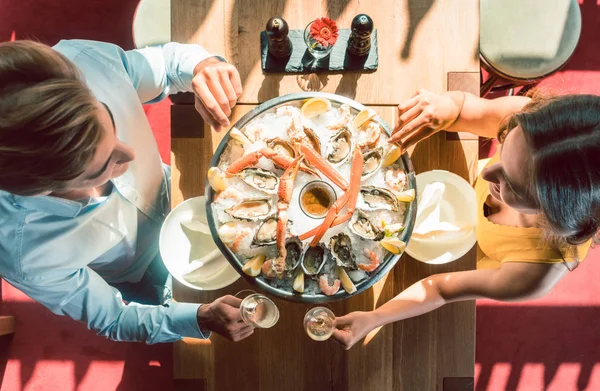 Glückliches junges Paar stößt beim romantischen Abendessen in einem angesagten Restaurant an — Stockfoto