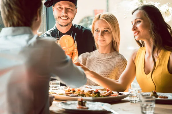 Erfahrener Koch gratuliert von vier Personen in einem trendigen Restaurant — Stockfoto