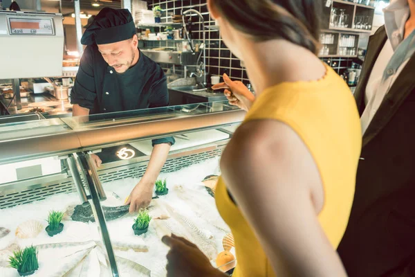 Chef experimentado tomando un pescado fresco del congelador para cocinarlo — Foto de Stock