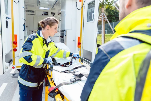 Paramédicos preparando maca em ambulância — Fotografia de Stock