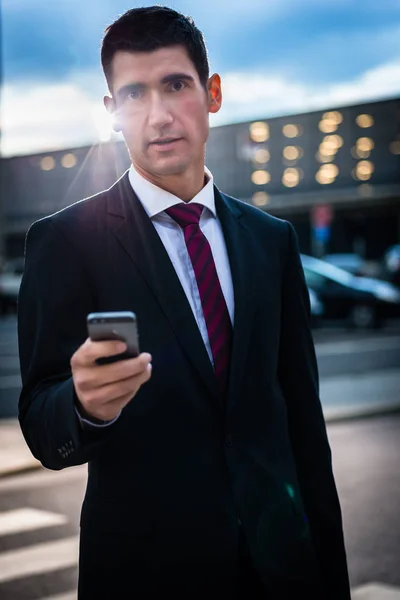 Biznes człowiek SMS-y na wieczór na zewnątrz — Zdjęcie stockowe
