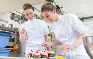 Pasta ekmek kek üzerinde çalışan iki fırıncı kadınlarda