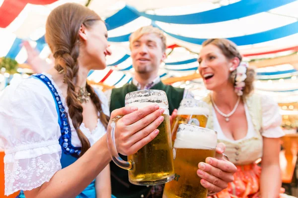Amigos com copos de cerveja na barraca de cerveja da Baviera — Fotografia de Stock