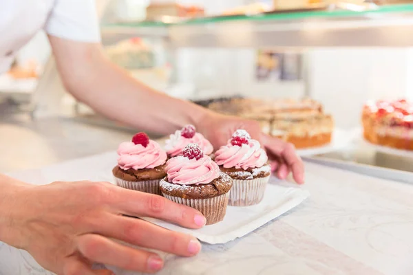 Kekler pastane dükkanı sergilenen koyarak kadın — Stok fotoğraf