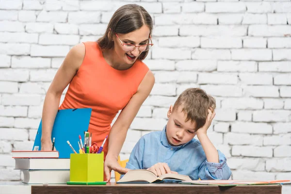 Matka, pomagając jej syna, aby zrobić pracę domową szkoły — Zdjęcie stockowe