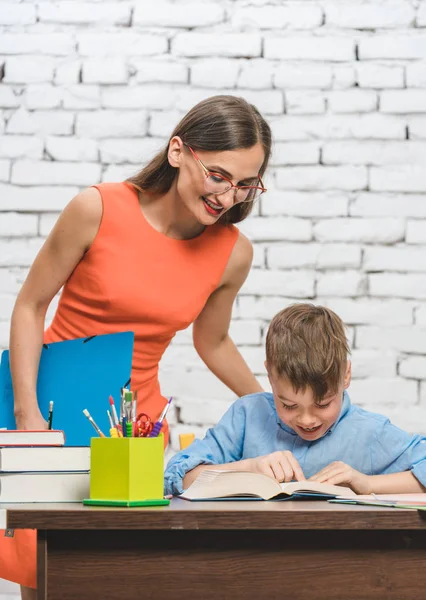 Madre ayudando a su hijo a hacer la tarea escolar — Foto de Stock