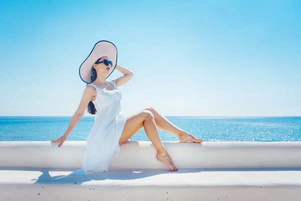 Kobieta siedzi na słońcu na greckiej plaży — Zdjęcie stockowe