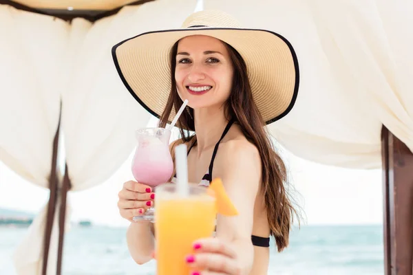 Kvinna med en cocktail på stranden som förfriskning — Stockfoto