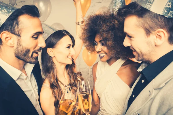 Hombres y mujeres celebrando fiesta mientras tintinean gafas — Foto de Stock