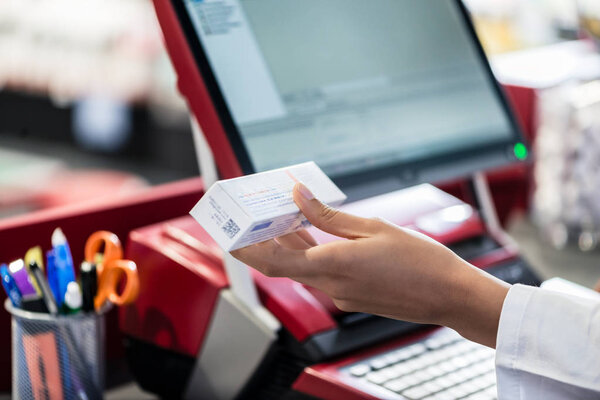 Рука фармацевта, держащего в руках лекарство с информацией о побочных эффектах
