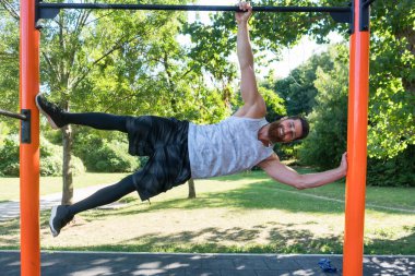 Kas Genç adam bir modern fitness parkta vücut ağırlığı egzersizleri yapıyor