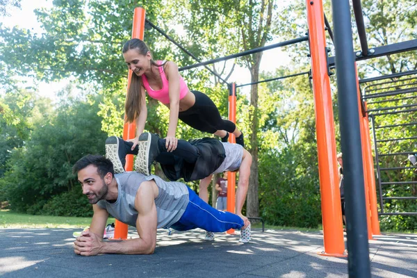 Tři přátelé tvořící pyramidu a přitom push-up a prkno cvičení — Stock fotografie