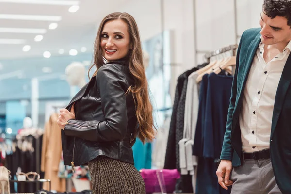 Žena se snaží novou koženou bundu v butiku módy — Stock fotografie