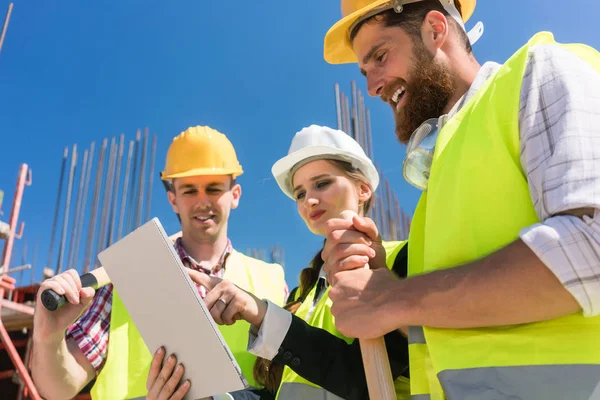 Arquiteta ou gerente mostrando aos seus colegas plano de construção eletrônica — Fotografia de Stock