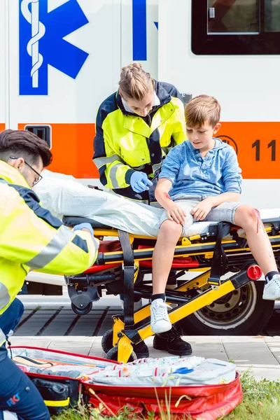 Emergency doctors caring for accident victim boy — Stock Photo, Image