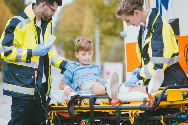 Medics putting injured boy on stretcher after accident