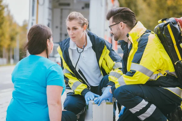 Noodgevallen dokters praten met gewonde vrouw — Stockfoto