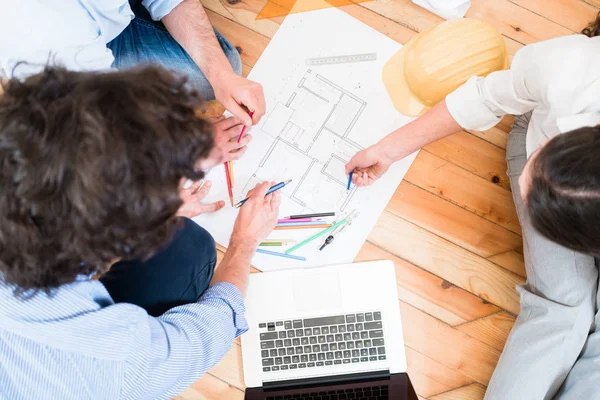 Architects bent over construction plans — Stock Photo, Image