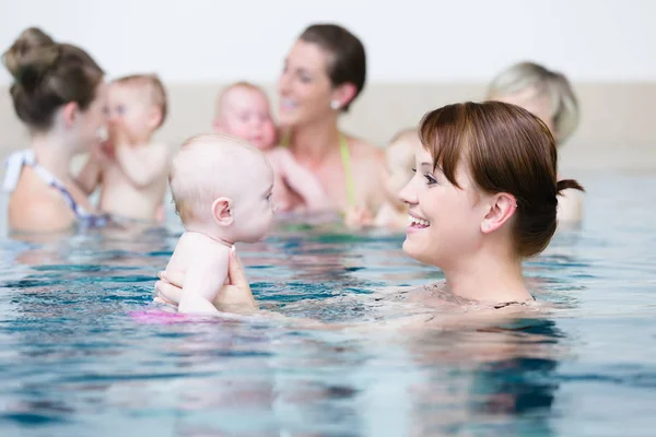 Gruppo di madri con bambini a lezione di nuoto per bambini — Foto Stock