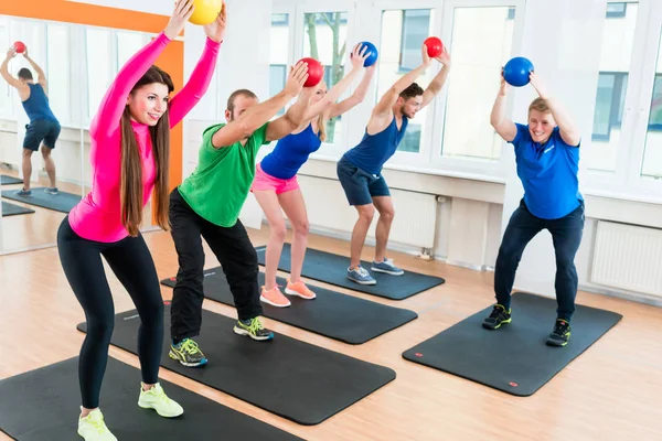 Hombres y mujeres en el gimnasio haciendo ejercicios de pilates —  Fotos de Stock