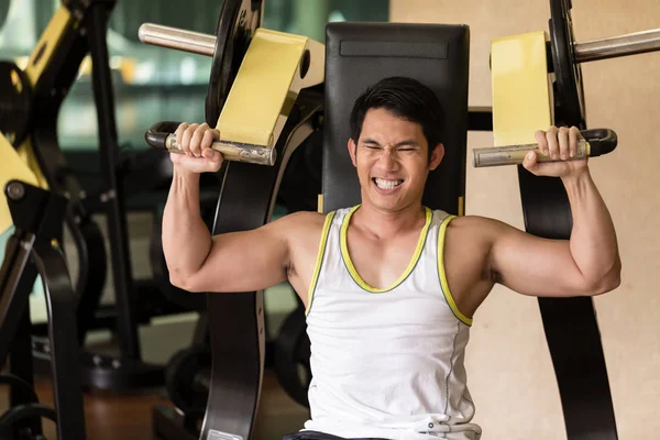 Hombre joven fuerte haciendo ejercicio para los músculos de los brazos en un club de fitness — Foto de Stock