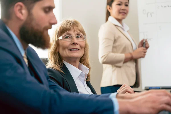 Retrato de una mujer de mediana edad durante una reunión de negocios — Foto de Stock