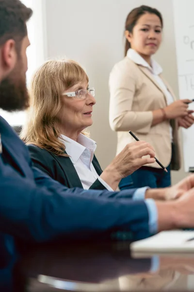 Retrato de una mujer de mediana edad durante una reunión de negocios — Foto de Stock