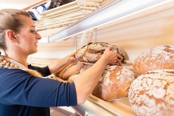 Bakery woman putting bread in shop shelf — Stock Photo, Image