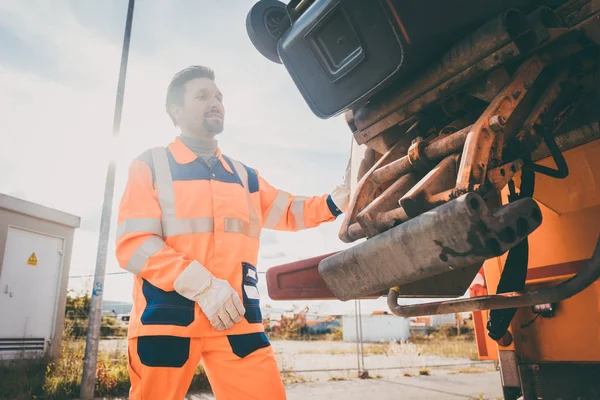 Zwei Mitarbeiter der Müllabfuhr laden Müll in Müllwagen — Stockfoto