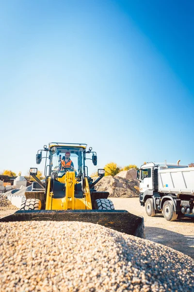 Yükleyici-Tekerlekli yükleyici ile toprak işleri yapıyor inşaat işçileri — Stok fotoğraf