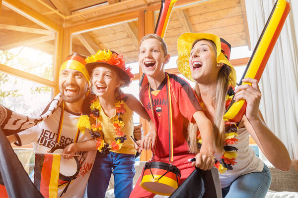 Whole family cheering for the German soccer team in front of TV
